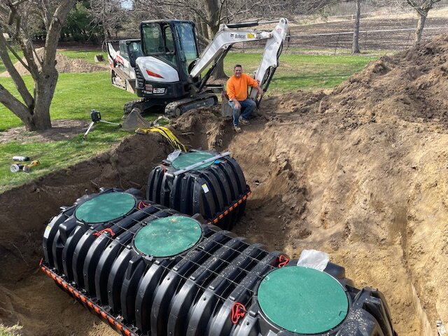 Septic tanks lowered into trench during installation in Mason, MI